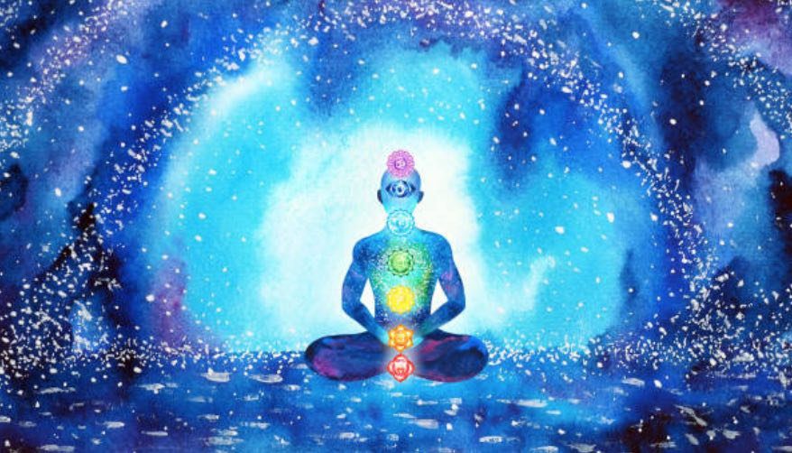Meditative figure surrounded by glowing energy and chakra lights.
